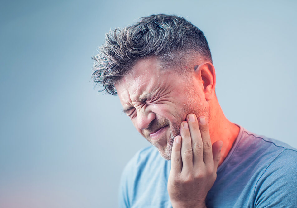 Man grabbing his jaw due to dental pain